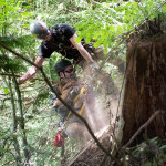 Two rescuers are being hauled up on the rope. Flint the dog is in their arms.