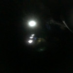 Headlamps illuminate the way down the trail in the dark.