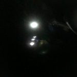 Headlamps illuminate the way down the trail in the dark.