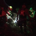 The team readies the attendants. Night time photo of harnessed people ready to go over a cliff.