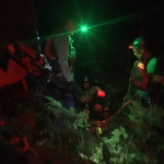 The attendants are ready to go. Night time photo of harnessed people ready to go over a cliff.